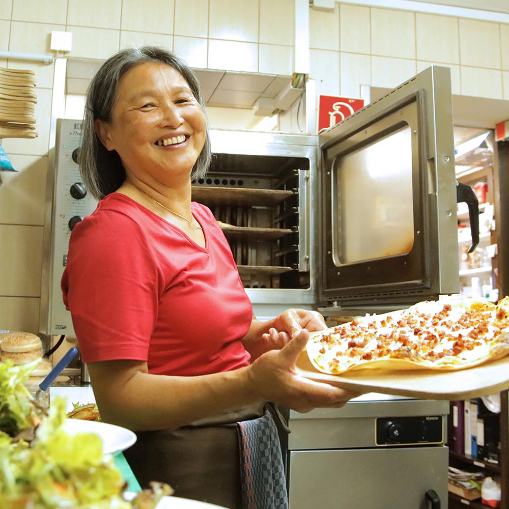 thymy hat Spaß in der Küche mit leckerem Flammkuchen in der Hand